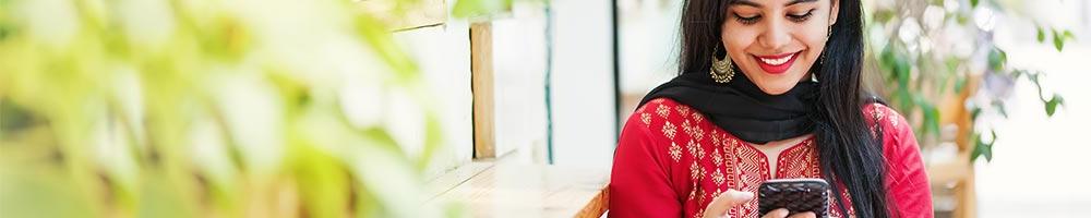 A woman on her smartphone smiling.